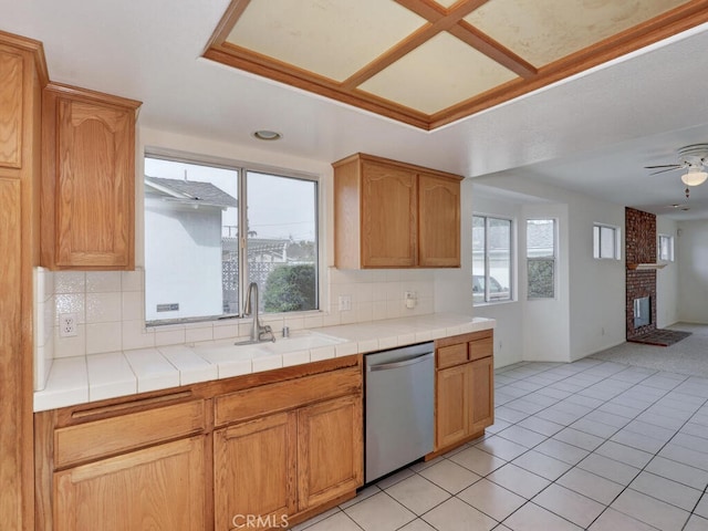 kitchen featuring stainless steel dishwasher, a healthy amount of sunlight, a ceiling fan, and tasteful backsplash