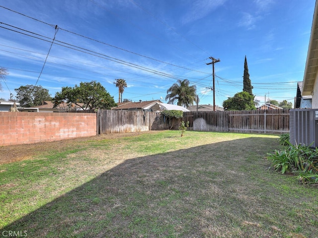 view of yard with a fenced backyard and central AC unit