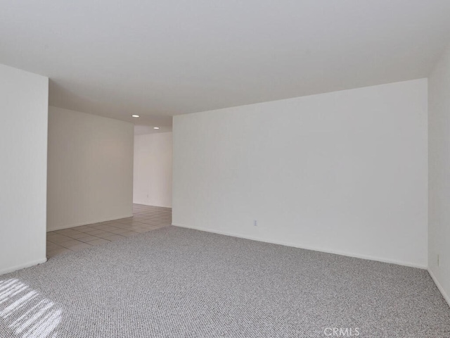 unfurnished room with light tile patterned flooring and light colored carpet