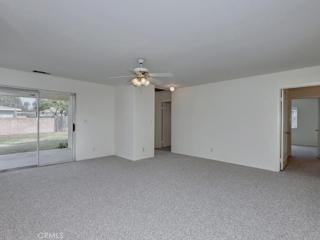 empty room featuring ceiling fan, visible vents, and light colored carpet