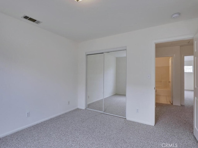 unfurnished bedroom featuring a closet, visible vents, baseboards, and carpet flooring