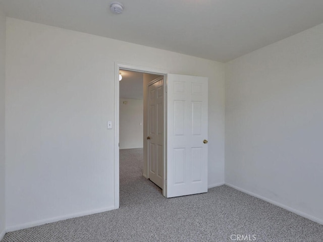 carpeted empty room with baseboards