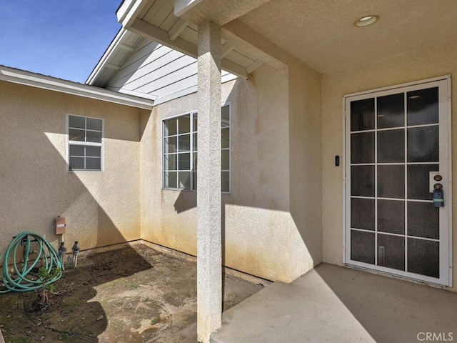 doorway to property with a patio area and stucco siding