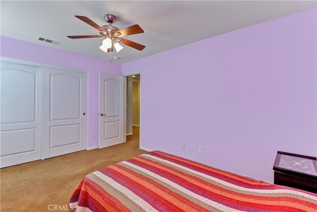 bedroom featuring a closet, carpet flooring, visible vents, and a ceiling fan