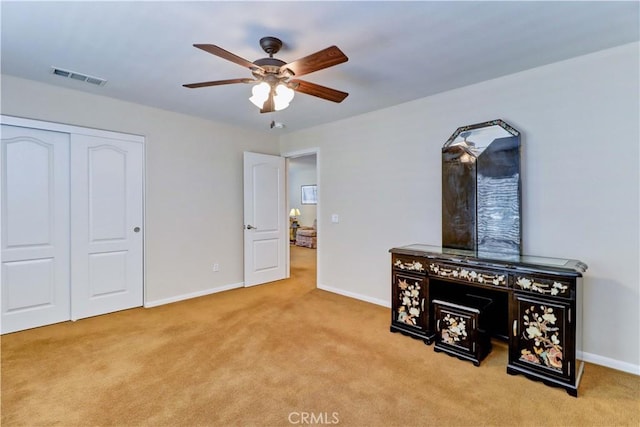 bedroom with light carpet, baseboards, visible vents, ceiling fan, and a closet