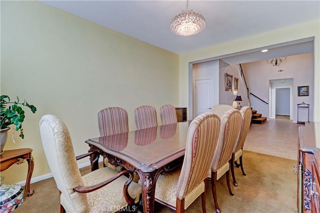 dining area with light colored carpet, a notable chandelier, visible vents, and stairs