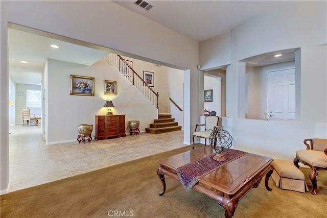 living area with carpet floors, recessed lighting, visible vents, tile patterned flooring, and stairs