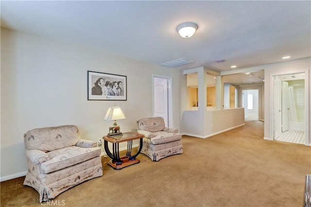 living area with carpet, visible vents, and baseboards