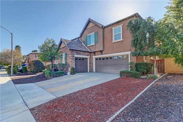 traditional-style home featuring stucco siding, concrete driveway, an attached garage, fence, and stone siding