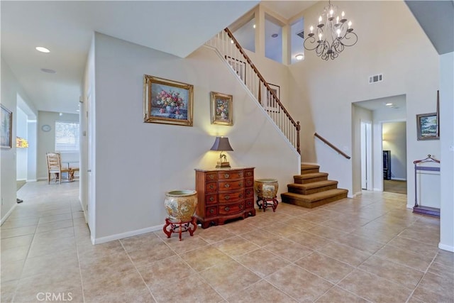 foyer entrance with stairway, light tile patterned flooring, visible vents, and a notable chandelier