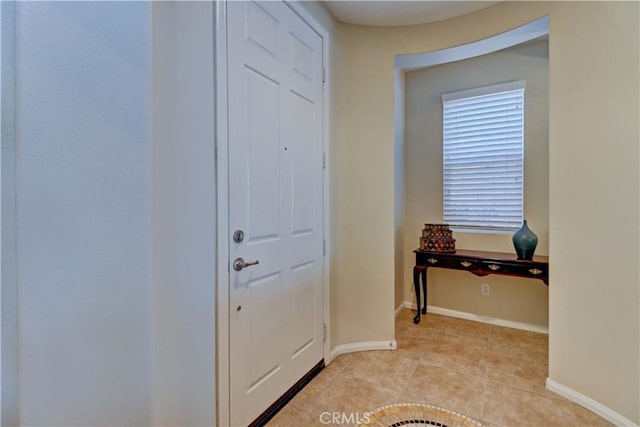 entryway with baseboards and light tile patterned floors