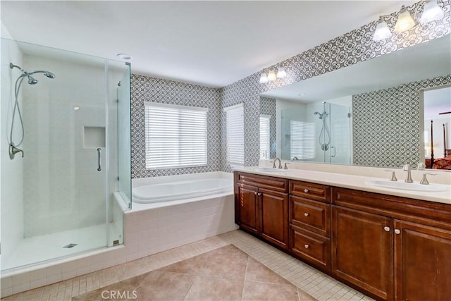 bathroom featuring double vanity, a stall shower, tile patterned floors, a sink, and a bath