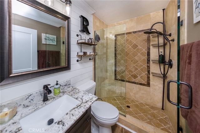 full bathroom featuring vanity, wood walls, a shower stall, and toilet