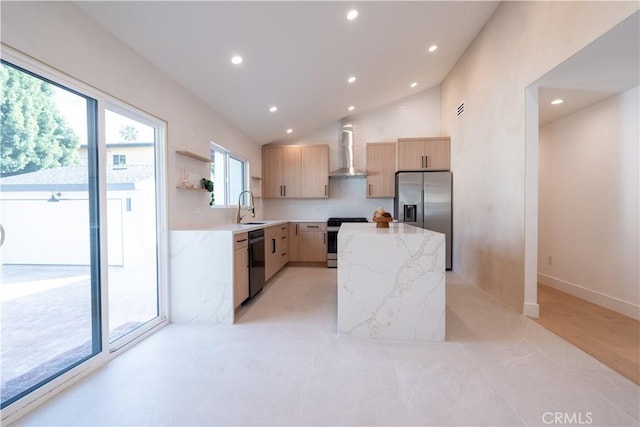 kitchen with a center island, appliances with stainless steel finishes, light brown cabinets, wall chimney range hood, and light stone countertops