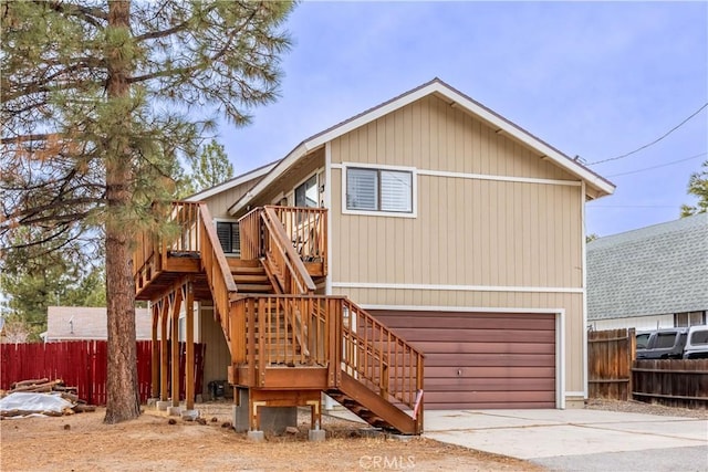 view of front of house featuring a garage, fence, stairway, and concrete driveway