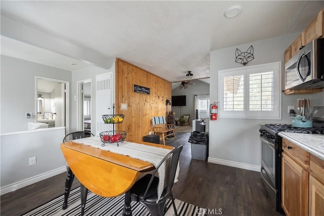 kitchen with light countertops, appliances with stainless steel finishes, dark wood-type flooring, and baseboards