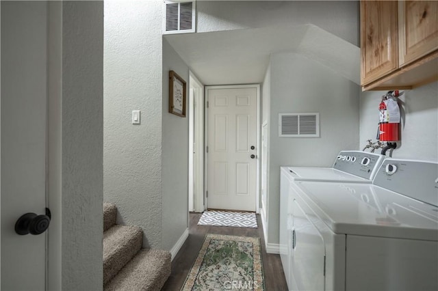 laundry area with dark wood-style floors, cabinet space, visible vents, and independent washer and dryer