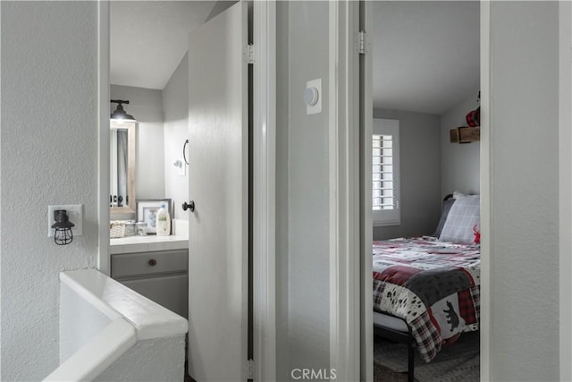 bathroom with a textured wall and vanity