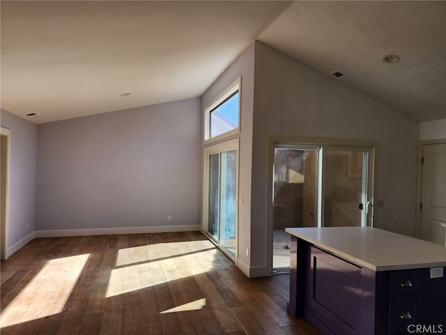 kitchen featuring visible vents, baseboards, dark wood-style flooring, vaulted ceiling, and light countertops