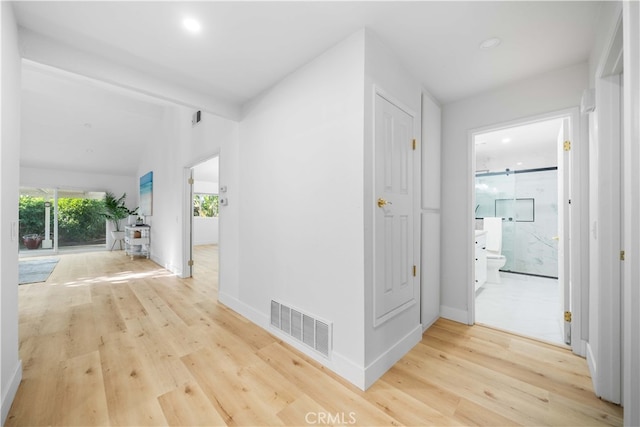 corridor with baseboards, visible vents, wood finished floors, and beamed ceiling