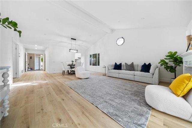 living area with vaulted ceiling with beams, light wood-style flooring, and baseboards