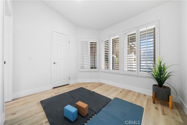 exercise area with wood finished floors and baseboards