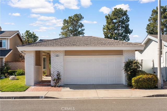 ranch-style house featuring a garage, a tile roof, brick siding, and driveway