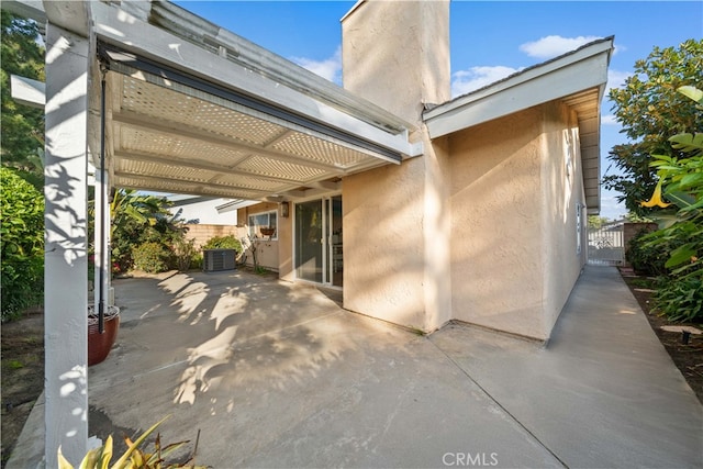 view of patio with central air condition unit, fence, and a pergola