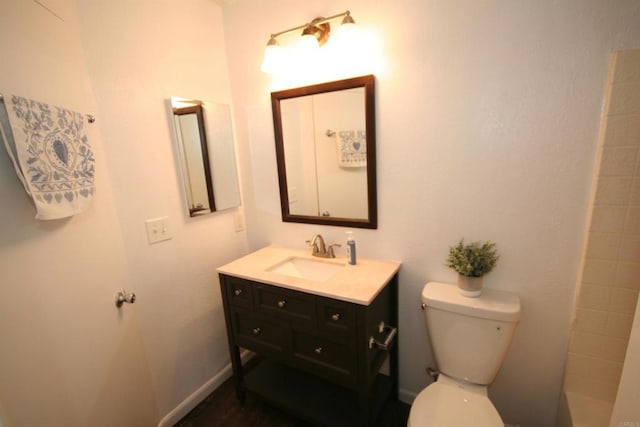 full bath featuring a shower, baseboards, vanity, and toilet