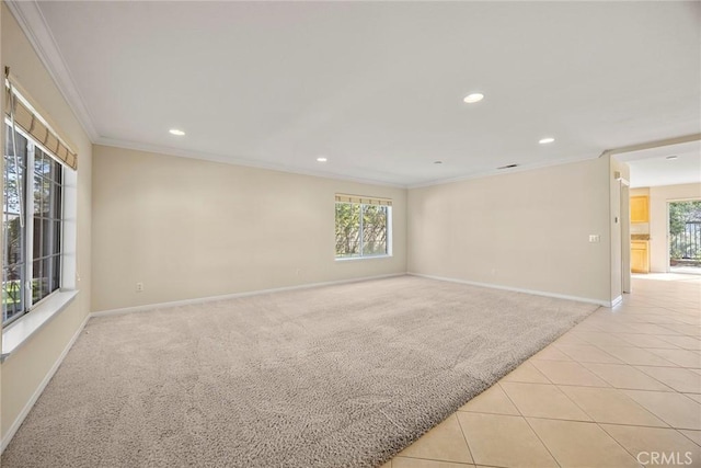 empty room with light tile patterned floors, recessed lighting, light carpet, baseboards, and crown molding