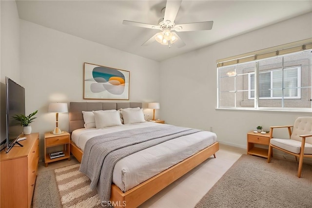 bedroom with ceiling fan, baseboards, and light colored carpet