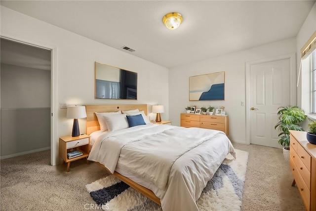 bedroom featuring visible vents, light carpet, and baseboards