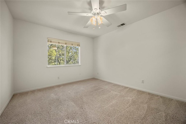 empty room featuring carpet, visible vents, ceiling fan, and baseboards