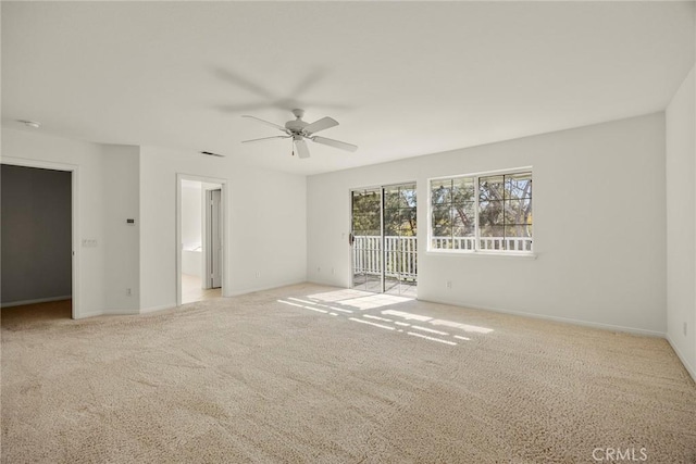 carpeted empty room with visible vents, ceiling fan, and baseboards