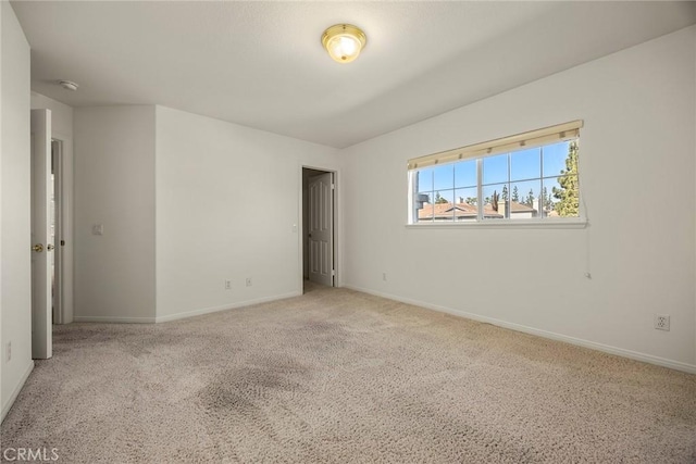 unfurnished room with carpet and baseboards