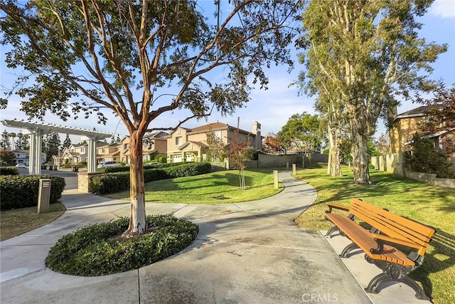 view of property's community featuring a residential view, fence, and a yard