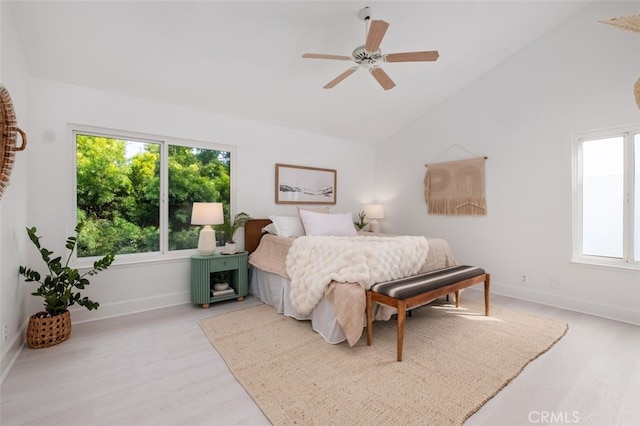 bedroom featuring lofted ceiling, light wood-style flooring, baseboards, and ceiling fan