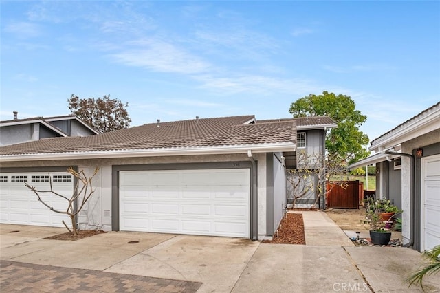 view of property with a garage, stucco siding, and a tiled roof