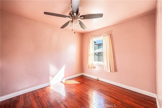 spare room featuring wood-type flooring, baseboards, and a ceiling fan