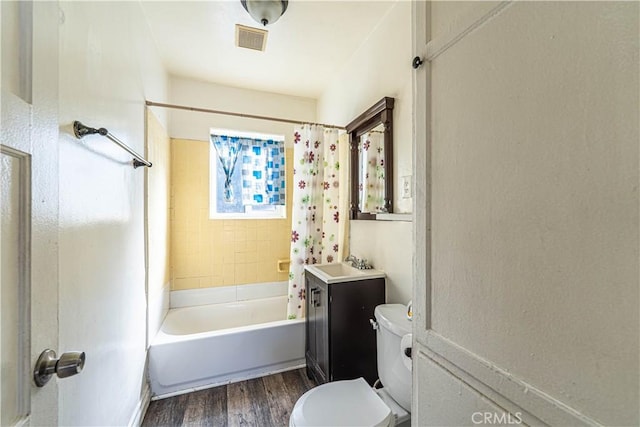 full bathroom featuring visible vents, toilet, shower / bath combo with shower curtain, vanity, and wood finished floors