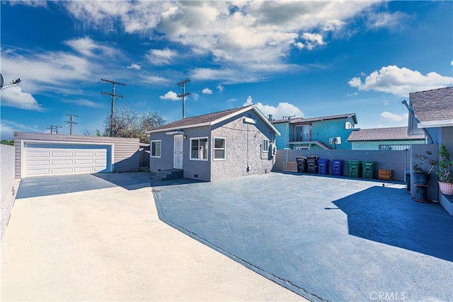 view of front facade with an outbuilding, a detached garage, fence, and entry steps