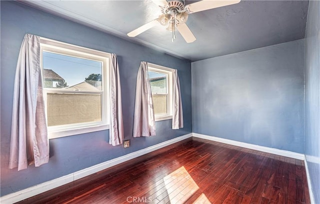 unfurnished room with wood-type flooring, baseboards, and a ceiling fan