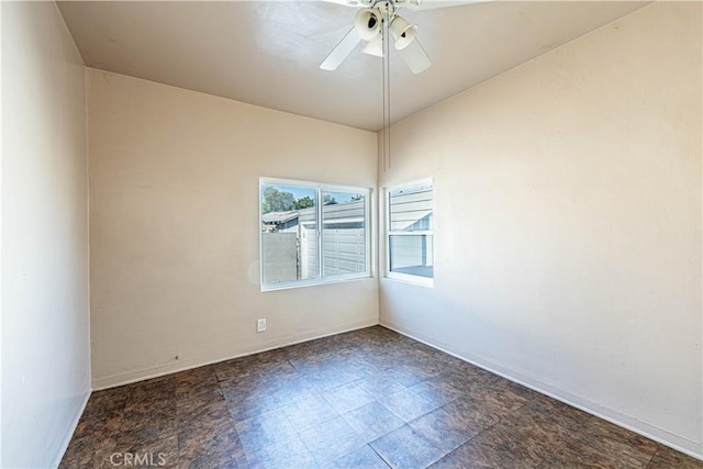 empty room with ceiling fan and baseboards