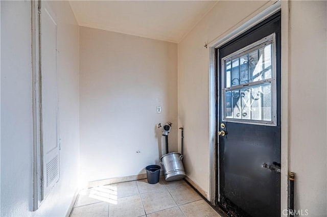 laundry area with light tile patterned floors and baseboards