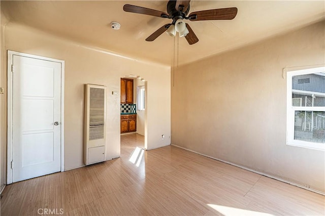 unfurnished bedroom with ceiling fan, connected bathroom, and light wood-style floors