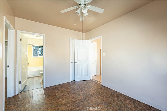 unfurnished bedroom featuring ensuite bathroom, a closet, stone finish floor, and baseboards