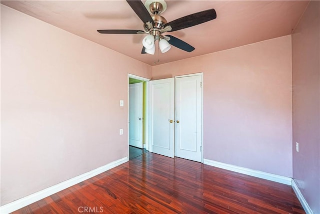 unfurnished bedroom with wood finished floors, a ceiling fan, and baseboards