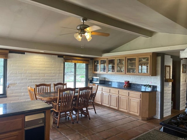 kitchen featuring decorative backsplash, lofted ceiling with beams, dark countertops, stainless steel appliances, and glass insert cabinets