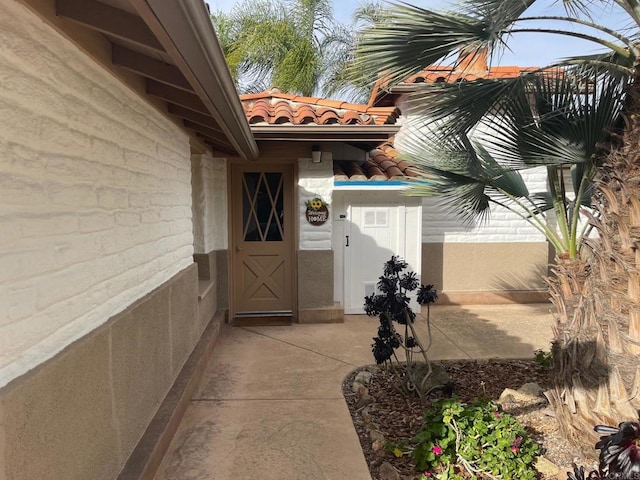 view of exterior entry featuring a tile roof