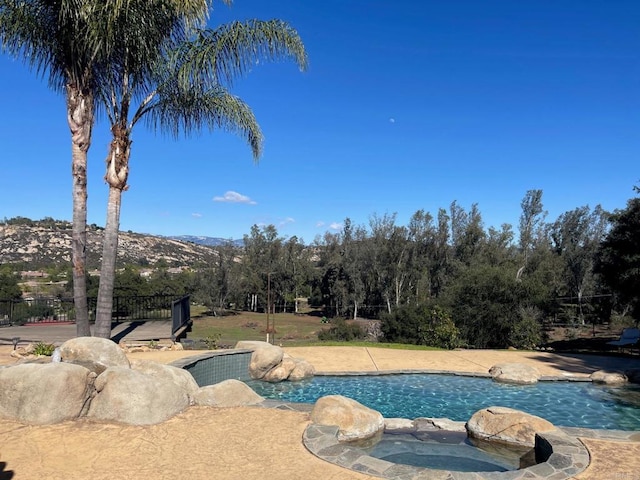 view of swimming pool featuring a pool with connected hot tub